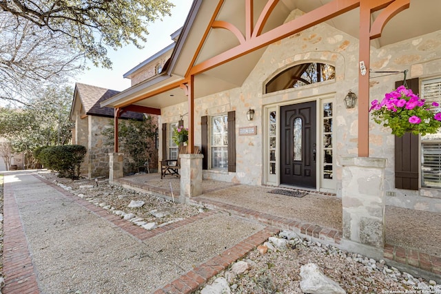 property entrance with stone siding and roof with shingles