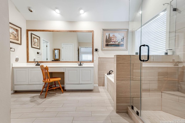 bathroom with double vanity, a stall shower, a sink, and a bath