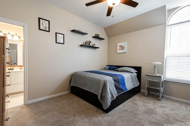 bedroom featuring lofted ceiling, ensuite bath, baseboards, and carpet flooring