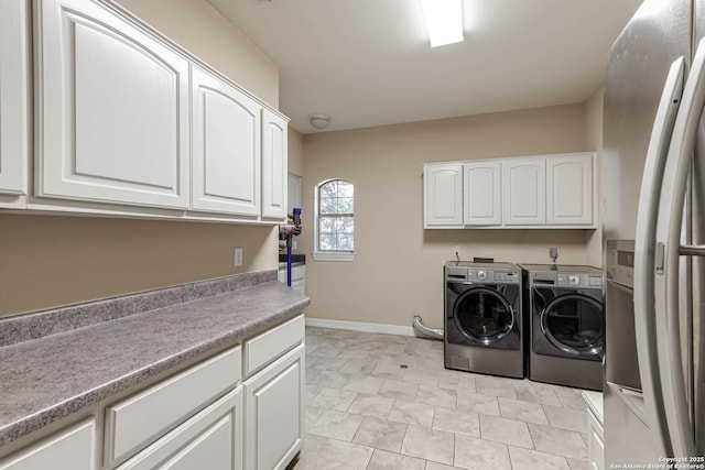 laundry room featuring cabinet space, baseboards, and independent washer and dryer