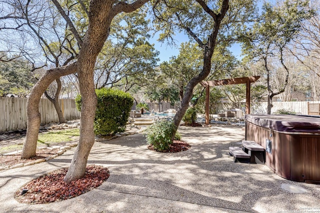 view of yard featuring a hot tub, a fenced backyard, and a patio