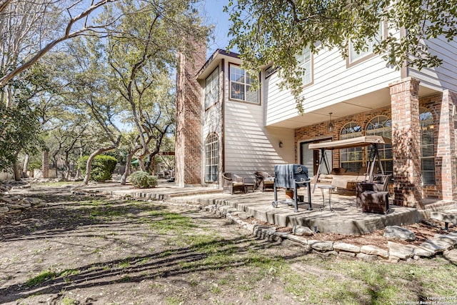 back of property with a patio area and brick siding