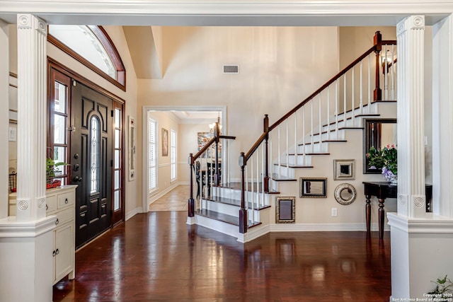 entrance foyer with baseboards, visible vents, a towering ceiling, dark wood-type flooring, and stairs