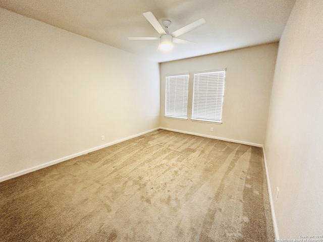 carpeted empty room with ceiling fan and baseboards