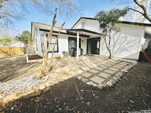 rear view of house featuring central air condition unit, a patio area, and fence