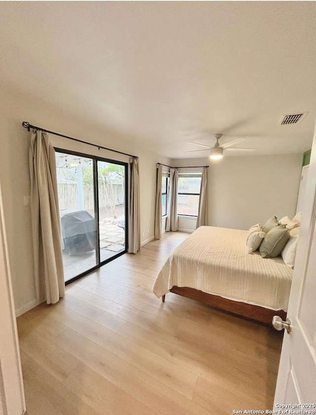 bedroom featuring access to exterior, visible vents, light wood-style flooring, and a ceiling fan