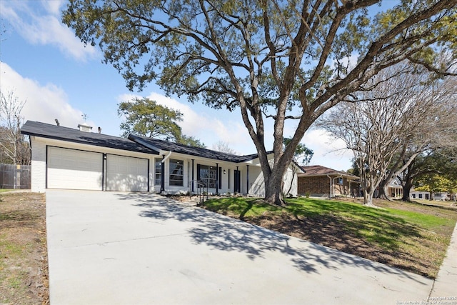 ranch-style house with a garage, a front yard, brick siding, and driveway