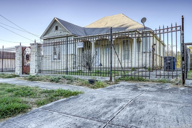 view of front of property featuring a fenced front yard and a gate