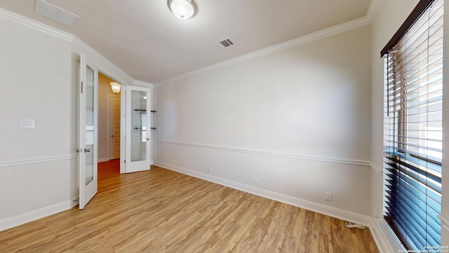 spare room with french doors, visible vents, light wood-style floors, ornamental molding, and baseboards