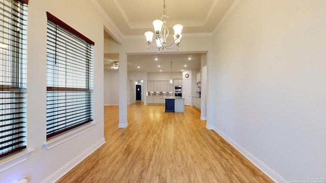 unfurnished dining area with recessed lighting, a raised ceiling, light wood-style flooring, baseboards, and ceiling fan with notable chandelier