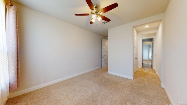 unfurnished bedroom with light carpet, ceiling fan, visible vents, and baseboards