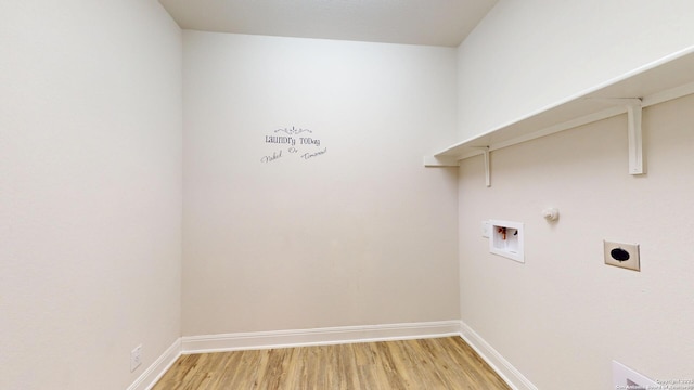 clothes washing area featuring hookup for a washing machine, hookup for an electric dryer, laundry area, baseboards, and light wood finished floors