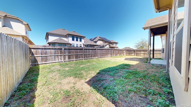 view of yard featuring a fenced backyard and a residential view