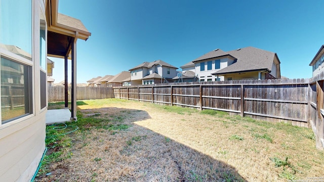 view of yard featuring a fenced backyard and a residential view