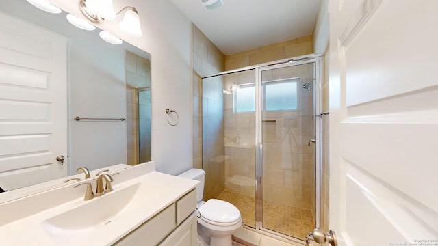 bathroom featuring a shower stall, toilet, and vanity