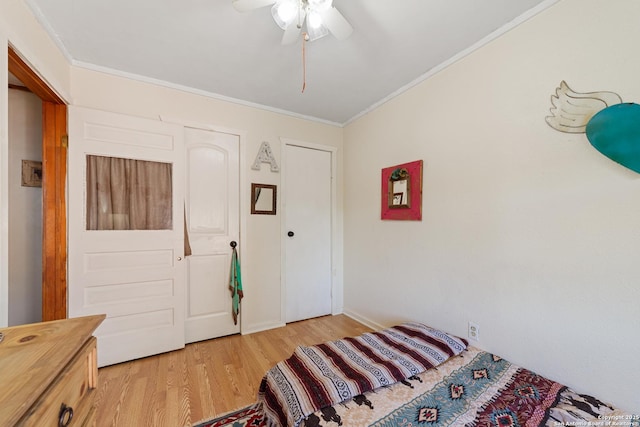 bedroom featuring light wood-style floors, ceiling fan, and ornamental molding