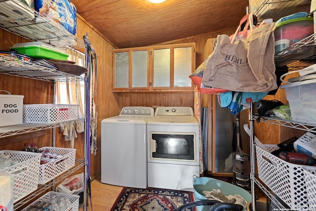 laundry area with cabinet space, wood walls, wood finished floors, washer and dryer, and wooden ceiling