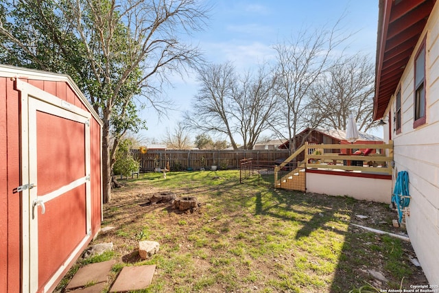 view of yard featuring an outbuilding, a storage unit, and a fenced backyard