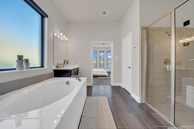 ensuite bathroom with visible vents, ensuite bathroom, a stall shower, wood tiled floor, and a tub with jets