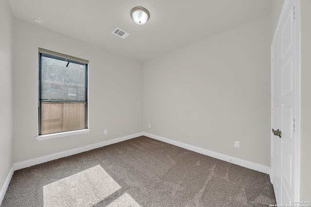 spare room with carpet, visible vents, and baseboards