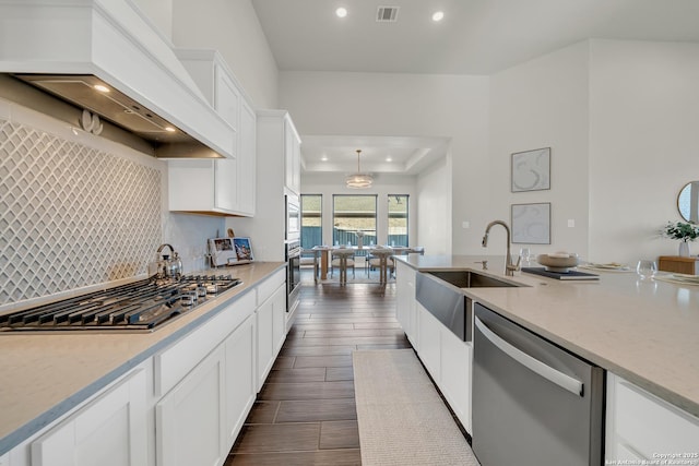 kitchen with tasteful backsplash, visible vents, appliances with stainless steel finishes, premium range hood, and white cabinetry