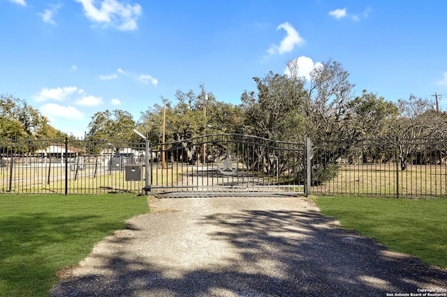 view of gate with a lawn and fence