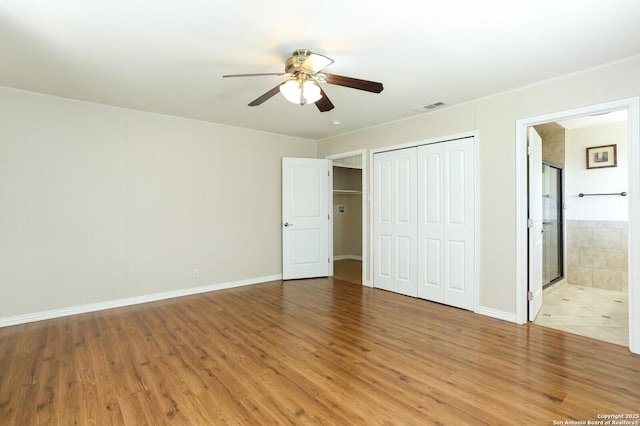 unfurnished bedroom with light wood-style flooring, crown molding, visible vents, and a closet