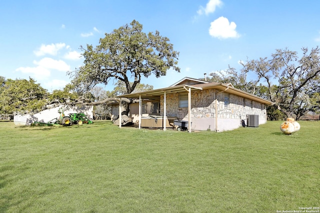 exterior space featuring central AC, stone siding, and a lawn