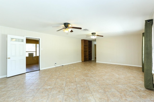 unfurnished room with visible vents, a ceiling fan, light tile patterned flooring, cooling unit, and baseboards