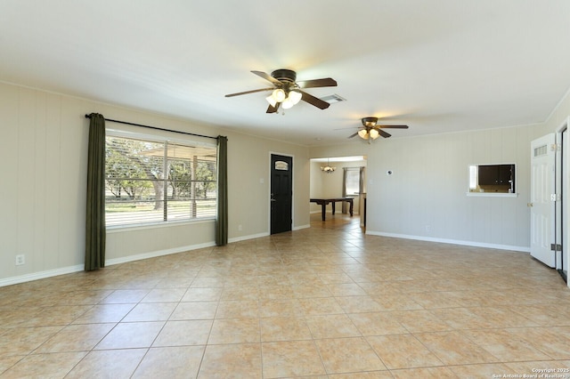 spare room featuring ceiling fan with notable chandelier, visible vents, baseboards, and light tile patterned floors