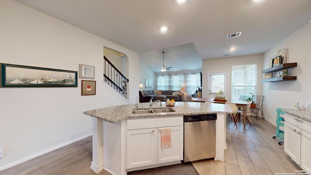 kitchen with visible vents, dishwasher, light stone counters, white cabinetry, and a sink