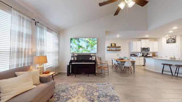 living room with ceiling fan, high vaulted ceiling, baseboards, and recessed lighting