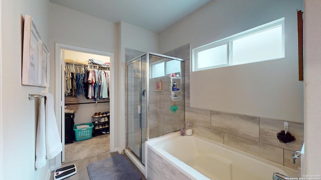 full bathroom featuring a stall shower, a walk in closet, and a garden tub