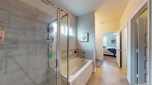 bathroom featuring a garden tub, wood finished floors, visible vents, a stall shower, and ensuite bath