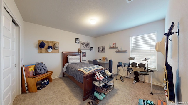 carpeted bedroom with a closet and baseboards