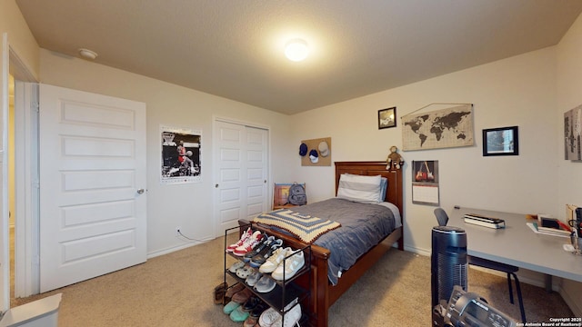 carpeted bedroom with a closet and baseboards