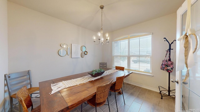 dining area featuring a chandelier, baseboards, and wood finished floors