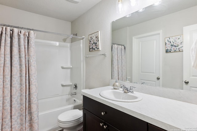 full bath with a textured wall, shower / tub combo with curtain, vanity, and toilet