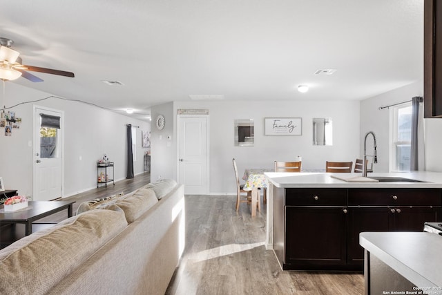 kitchen with light wood-style floors, light countertops, a sink, and open floor plan