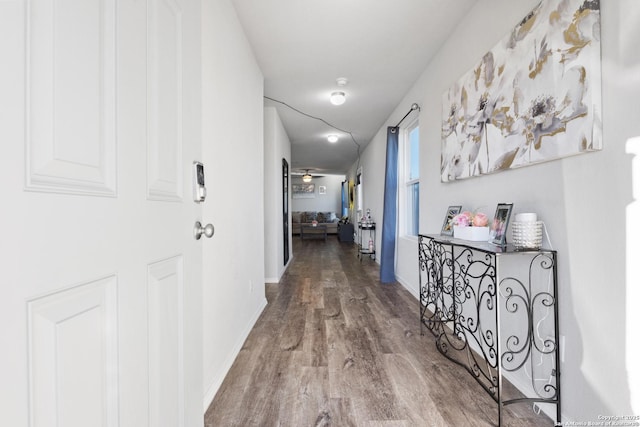 hallway with wood finished floors and baseboards