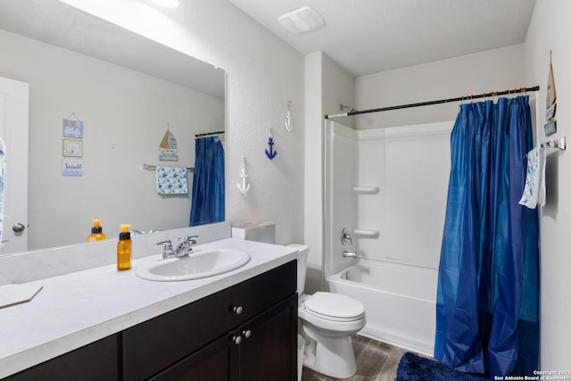 full bath with a textured wall, toilet, shower / bath combo with shower curtain, vanity, and wood finished floors