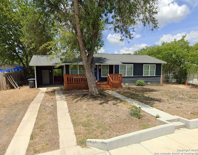 single story home featuring crawl space, a shingled roof, fence, and a carport