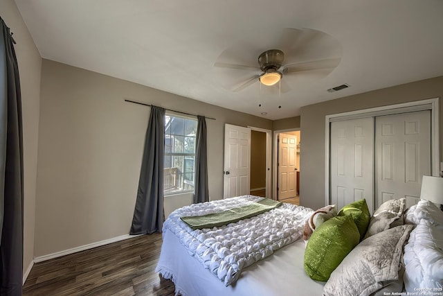 bedroom with visible vents, baseboards, ceiling fan, wood finished floors, and a closet