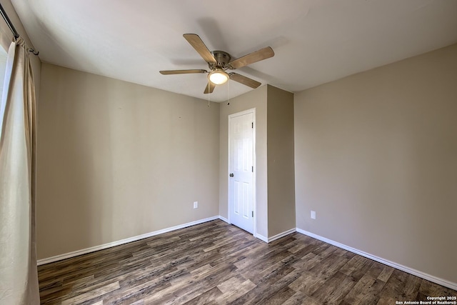 unfurnished room featuring dark wood-type flooring, ceiling fan, and baseboards