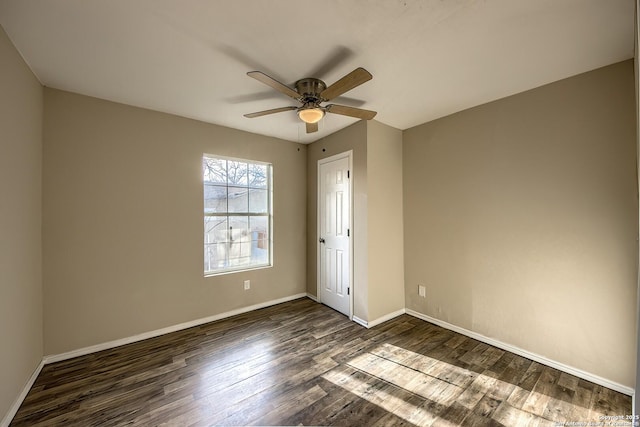 unfurnished bedroom featuring dark wood-type flooring, baseboards, and a ceiling fan