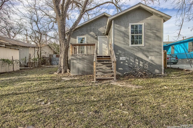 back of house featuring a yard, crawl space, and fence