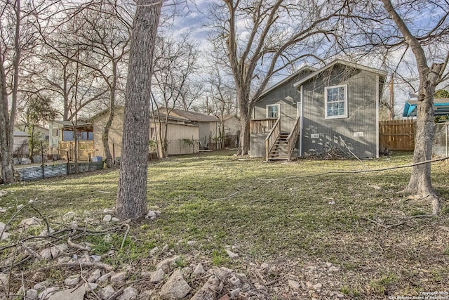 view of yard with stairs and fence