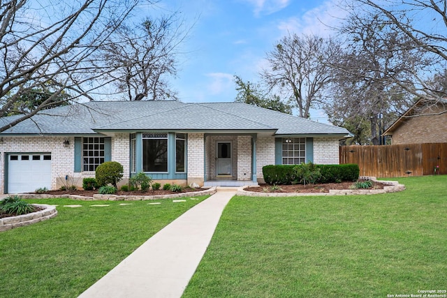 ranch-style home featuring a garage, brick siding, a front lawn, and fence