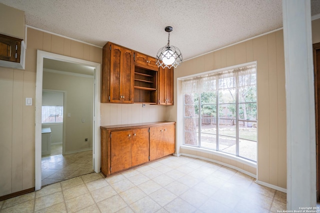 kitchen featuring a textured ceiling, open shelves, brown cabinetry, and crown molding