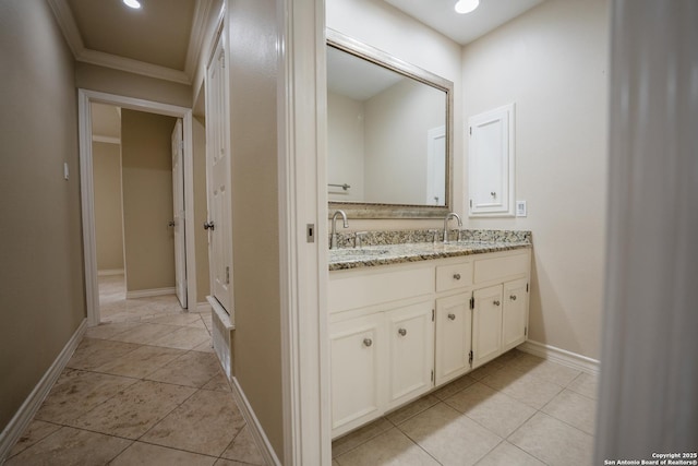 full bathroom with tile patterned flooring, a sink, baseboards, and double vanity